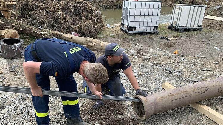 Markus Rupprecht (kniend) und Christian Reinlein bereiten ein Abflussrohr fürs Verladen vor.  Foto: THW Kulmbach