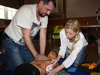 Jede Menge Praxis: Während Jens Endreß die Herzdruckmassage macht, klebt seine Kollegin Tanja Endreß die Elektroden für das Laien-Defibrilationsgerät an den Brustkorb der Übungspuppe. Foto: Ralf Ruppert