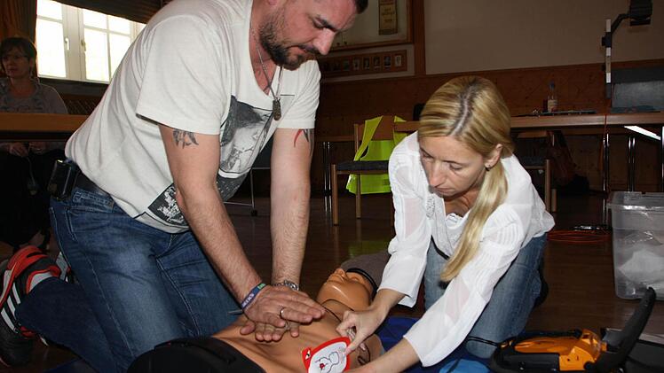 Jede Menge Praxis: Während Jens Endreß die Herzdruckmassage macht, klebt seine Kollegin Tanja Endreß die Elektroden für das Laien-Defibrilationsgerät an den Brustkorb der Übungspuppe. Foto: Ralf Ruppert