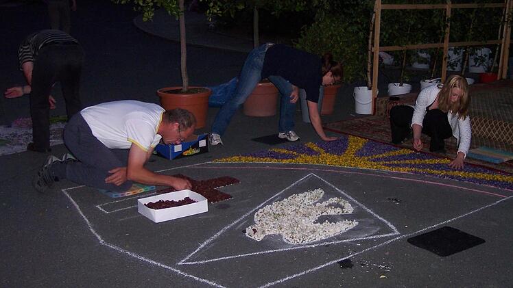 Ganz leise im Dunkeln legten die Stadtsteinacher den Teppich - der Kirchplatz wurde von Autoscheinwerfern erleuchtet. Foto: Sonny Adam