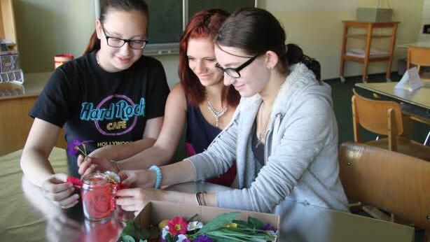 Vanessa Mai (15), Laura Kellner (13) und Petra Bär (14) dekorieren Windlichter und recyceln so alte Gläser.