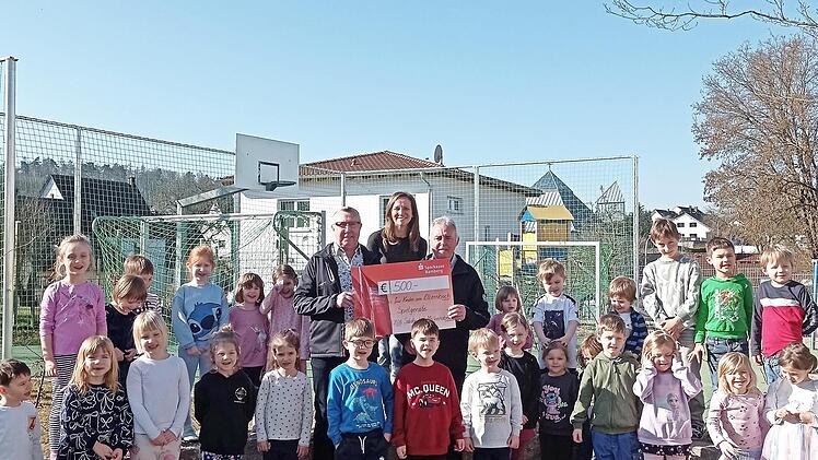 Vorsitzender Harald G&ouml;tz (hinten rechts) und Zweiter Vorsitzender Robert Puff (hinten links) &uuml;berreichen der Leiterin der Einrichtung, Diana D&ouml;ppmann den Spendenscheck.