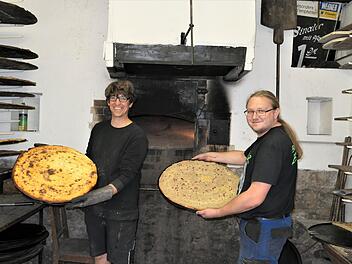 K&auml;seplootz raus aus dem Ofen, Zwiebelplootz rein in den Ofen: Die beiden FCSH B&auml;cker Sascha Greubel (links) und  Andreas Ostermiller  sorgten am Wochenende im Backhaus Ebenhausen stets f&uuml;r die Spezialit&auml;ten beim Backhausfest. Foto: Elisabeth Mehn