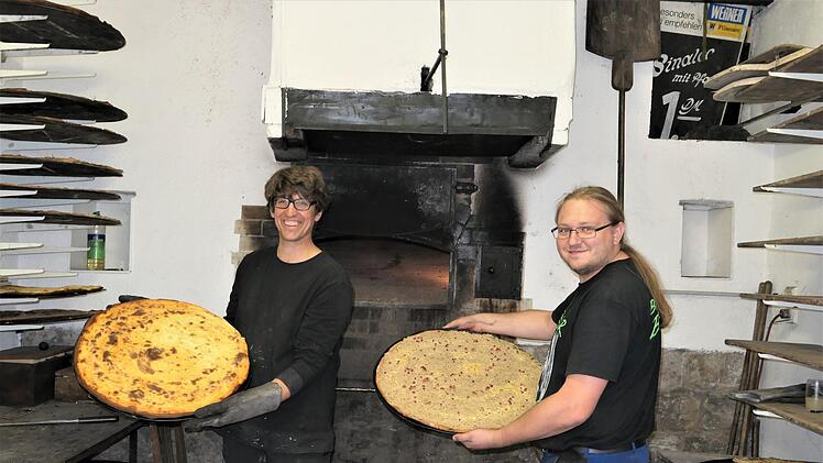 K&auml;seplootz raus aus dem Ofen, Zwiebelplootz rein in den Ofen: Die beiden FCSH B&auml;cker Sascha Greubel (links) und  Andreas Ostermiller  sorgten am Wochenende im Backhaus Ebenhausen stets f&uuml;r die Spezialit&auml;ten beim Backhausfest. Foto: Elisabeth Mehn
