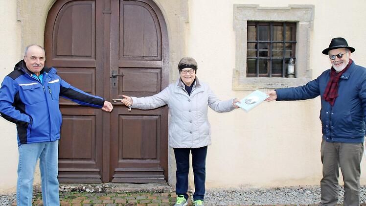 Martha Seufert erhält das Fotobuch "Sulzler Kreuzkirchle" aus den Händen von Bürgermeister August Weingart und übergibt den Schlüssel für die Kapelle an ihren Neffen Erhard Tremer.  Foto: Hilmar Ruppert