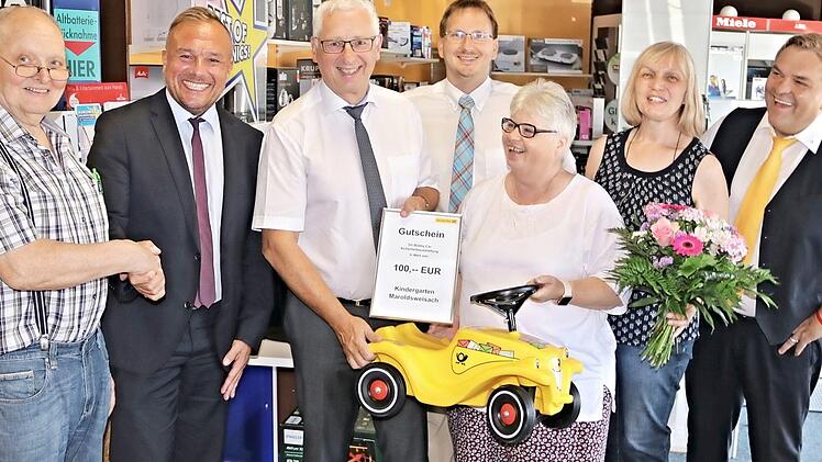 Drei Bobby-Cars konnte Elisabeth Endreß (Dritte von rechts) anlässlich der Eröffnung der Postfiliale für den Kindergarten in Empfang nehmen. Weiter auf dem Bild (von links): Peter Keil, Olaf Gunzelmann, Helmut Muhr (Deutsche Post), Bürgermeister Wolfram Thein, Heidi Keil und Stefan Hollfelder (Deutsche Post).  Foto: Helmut Will