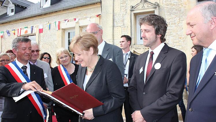 Bundeskanzlerin Angela Merkel unterschreibt die Partnerschaftsurkunde (links: Zweiter Bürgermeister Francois Vannier).