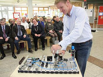 Schulleiterin Elisabeth Bräuning (erste Reihe, dritte von links) freut sich über die Spende von Michael und Christian Waasner (von links).  Oberstudienrat Christian Sturany erklärt den Gästen die Funktionsweise der Steuerung. Foto: Hofbauer