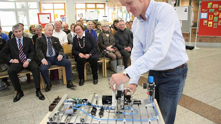 Schulleiterin Elisabeth Bräuning (erste Reihe, dritte von links) freut sich über die Spende von Michael und Christian Waasner (von links).  Oberstudienrat Christian Sturany erklärt den Gästen die Funktionsweise der Steuerung. Foto: Hofbauer