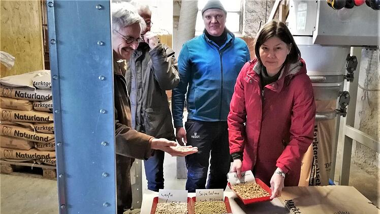Landwirt Jürgen Herrle (Mitte) zeigt Staatssekretärin Dr. Manuela Rottmann und Richard Mergner, Landesvorsitzender Bund Naturschutz, eine Auswahl des auf dem Zehntfreyhof Neder produzierten Saatguts.