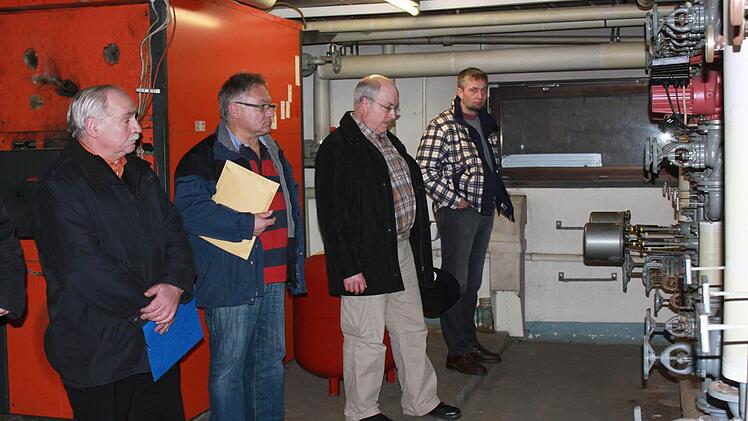 Bürgermeister Hermann Martin, Josef Kneuer, Klaus Dünisch und Ralf Nowak (von links) begutachten die Installation im Heizraum. Die Überdimensionierung der Heizung ist schon allein an der Vielzahl der Rohre und Leitungen ersichtlich. Foto: Katharina Becht