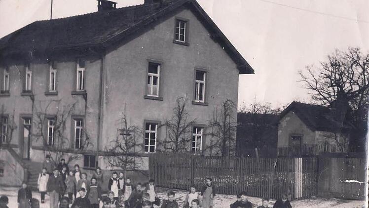 Ein Bild aus alten Zeiten zeigt die Kinder während der Pause vor dem Schulhaus.  Repro: Archiv Günther Straub