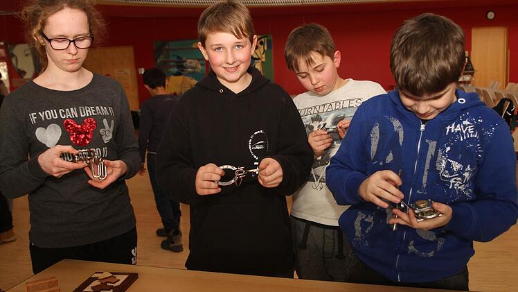 Die Schüler Yvonne, Lars, Maurice und Marco beim Problemlösen an Metallvexieren, die man auch von Zauberern kennt. Foto: Günther Geiling