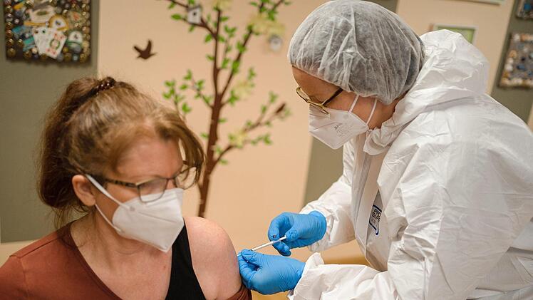 Pflegerin Maria (l.) wird mit dem Corona-Virus Impfstoff von Biontech/Pfizer geimpft. Foto: Nicolas Armer/dpa