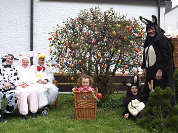 Osterhasen 2014: Die Ruhe vor dem Sturm: Die beiden Osterhasen Linde Kolb (stehend) und Sybille Simon (liegend) vor ihrem großen Eierstrauch mit dem "Osterei" Heidi im Korb und dem "Osterhasennachwuchs" auf der Bank. Von links "Kuh" Lenz Lindenberger, "Hase" Leni Lindenberger und "Gockel" Paul Höring. Foto: Susanne Deuerling