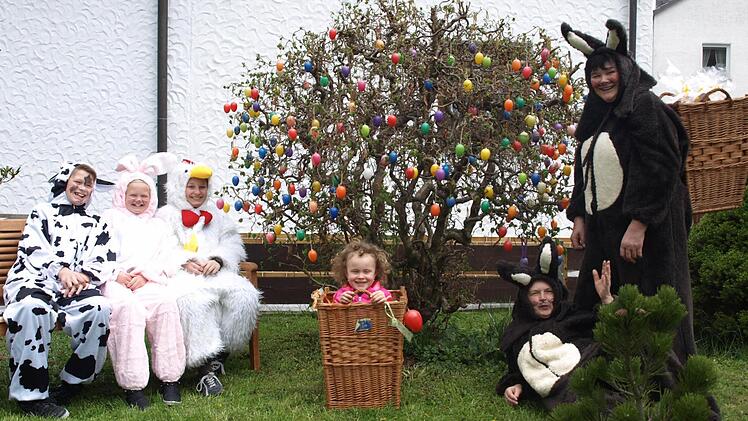 Osterhasen 2014: Die Ruhe vor dem Sturm: Die beiden Osterhasen Linde Kolb (stehend) und Sybille Simon (liegend) vor ihrem großen Eierstrauch mit dem "Osterei" Heidi im Korb und dem "Osterhasennachwuchs" auf der Bank. Von links "Kuh" Lenz Lindenberger, "Hase" Leni Lindenberger und "Gockel" Paul Höring. Foto: Susanne Deuerling