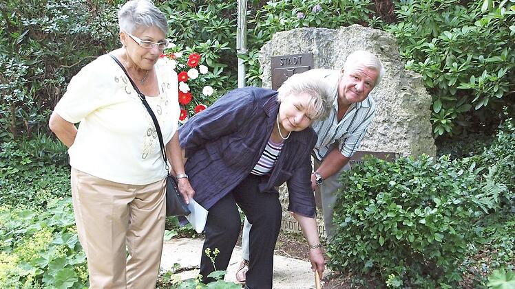 Gerda Ott (Mitte), die Ortsbetreuerin der Deutschhauser, vermischt die vom ehemaligen Deutschhauser-Bürgermeister Lubomir Stefaniak (rechts) und seiner Frau Ursula (links) mitgebrachte Erde mit der heimischen. Foto: Alfred Thieret