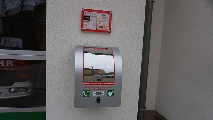 Direkt am Feuerwehrhaus Großwenkheim hängt der neue Defibrillator, der in Notfall Ersthelfer durch eine dauerhafte Telefonverbindung mit der Leitstelle Schritt für Schritt anleitet.  Foto: Max Pfennig