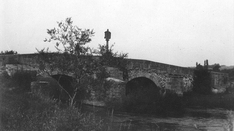 Die alte Klosterbrücke war ein  Schmuckstück. Hinter dem Baum ist der Heilige Nepomuk zu erkennen, der noch heute an der Brücke steht. Der Bildstock im Vordergrund wurde nie geborgen und liegt wohl - vermutlich pulverisiert - noch immer in der Saale, denn 1945 wurde die Brücke gesprengt,  um das Vorrücken der Amerikaner zu verhindern. Repro: Bernd Czelustek