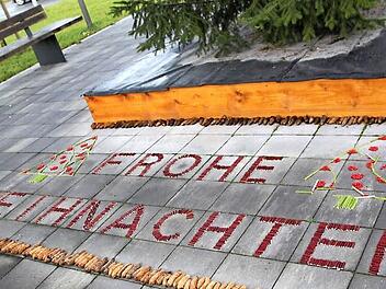 Tannenzapfen und kleine Holzstücke als Material - ein Schriftzug ziert den Weihnachtsbaum am Eingang des Kurbereichs. Fotos: Matthias Einwag
