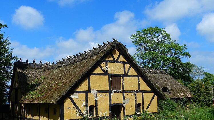 Im Sonnenschein geht es bei frischem Wind vorbei an alten, reetgedeckten Landhäusern.