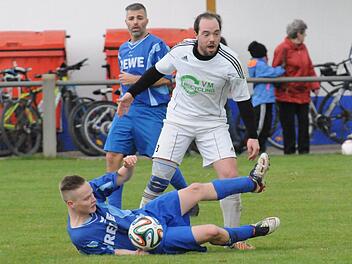 Den Weg versperrt: Der Ramsthaler Philipp Schmitt (am Boden) schützt den Ball vor dem Westheimer Tobias Wende. Dahinter beobachtet der Ramsthaler Spielertrainer Thorsten Büttner das Geschehen. Foto: ssp