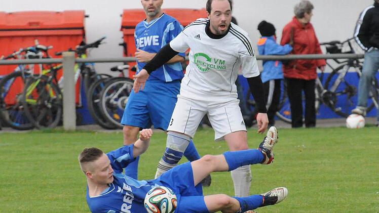 Den Weg versperrt: Der Ramsthaler Philipp Schmitt (am Boden) schützt den Ball vor dem Westheimer Tobias Wende. Dahinter beobachtet der Ramsthaler Spielertrainer Thorsten Büttner das Geschehen. Foto: ssp
