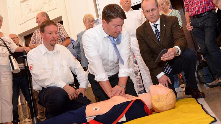 Unter fachkundiger Leitung "reanimiert" hier MdL Sandro Kirchner eine Übungspuppe. Ihm stehen Rotkreuz-Ausbilder Thomas Menz (links) und BRK-Kreisvorsitzender Bad Kissingen, Dr. Alexander Siebel (rechts) zur Seite. Foto: Peter Rauch
