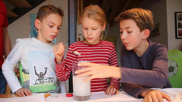 Spannend: Johann und Elisabeth Ruppert sowie Noah Troll beobachten die Reaktion von Flüssigkeiten. Foto: Ralf Ruppert