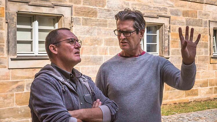 Regisseur Ruppert Everett (rechts) bespricht im Oberen Schlosshof die Filmproduktion in Thurnau.