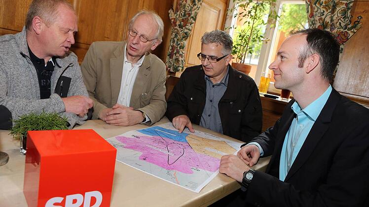 Auf einem Bamberger Stadtplan sind die neuen "Reviere" der drei SPD-Ortsvereine farblich dargestellt: Pink ist Altstadt-Süd, Blau Gaustadt und Ocker Ost/Gartenstadt/Kramersfeld. Das neue Führungsquarteett mit den Ortsvorsitzenden Lothar Kandzora, Ernst Trebin, Kreisvorsitzendem Felix Holland und Ortsvorsitzendem Dieter Stößel (von links) blickt sichtlich zufrieden auf die Karte. Foto: Matthias Hoch