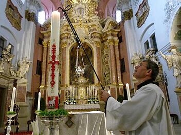 Die Osterkerze 2017 brennt auch in allen Bamberger Kirchen. Hier wird sie gerade von Mesner Johann Czerlau für den Abendgottesdienst am Ostersonntag in St. Martin entzündet. Foto: Marion Krüger-Hundrup