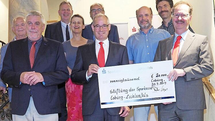 Glückliche Gesichter im Rathaus: Den Sammelscheck präsentieren Sparkassen-Direktor Martin Faber (vorne rechts) und Vorstand Roland Vogel. Die Empfänger der Ausschüttung (von links): Alfons Hrubesch (Opferhilfe Oberfranken), OB Norbert Tessmer, Michael Amthor (Tourismus Coburg), Susanna Curtis (Klinik-Clowns), Peter Märkel (Fränkischer Sängerbund) sowie Thomas Fuchs und Hans-Jürgen Metzner (Waldorfschulverein). Foto: Christoph Winter
