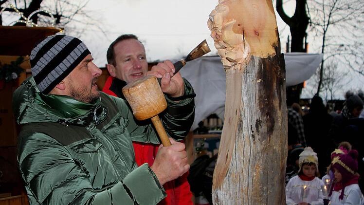 Holzschnitzer Jonas Pitscheider aus dem Grödnertal (links) wird hier von Bürgermeister Michael Ziegler ganz genau bei seiner Arbeit beobachtet; der Südtiroler schnitzte während des Marktes einen Engel..