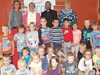 Kindergartenleiterin Erika Felix (links), Pfarrer George Thottankara (Zweiter von rechts) und die Kindergartenbeauftragte der Kirchenstiftung, Hedwig Träger (rechts), sowie ein Teil der 75 Kindergartenkinder gratulierten Nicole Wagner (Zweite von links) zu ihrem Dienstjubiläum. Foto: Alfred Thieret