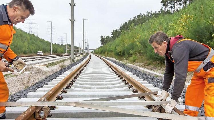 Die Bahnmitarbeiter Peter Albertz (links) und Valerie Bonda winkeln bei Wolfsberg (Thüringen) Schienen am künftigen Überholbahnhof Ilmenau-Wolfsberg der ICE-Neubaustrecke Ebensfeld-Erfurt aus. Foto: Michael Reichel/dpa