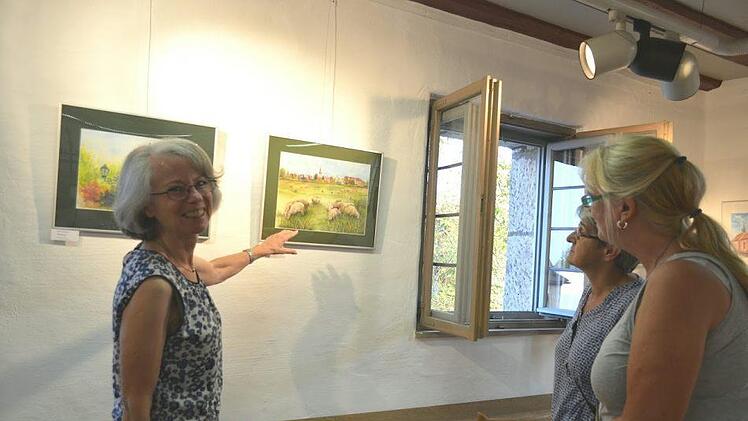 Die Schafherde auf den Aischwiesen ist nur eines von zwölf Motiven, die die Künstlerin Elke Meegrün (links) in einem Kalender zusammengefasst hat.  Fotos: Larissa Händel