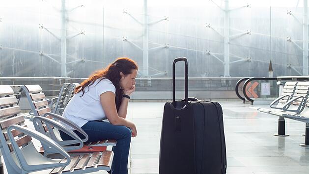 Flugversp&auml;tung oder -ausfall, traurige, w&uuml;tende Passagierin am Flughafen, Reiseversicherung  Wartezeit Frust Versp&auml;tung Reise Urlaub &Auml;rger flight delay or cancellation, sad angry woman passenger in airport, travel insurance