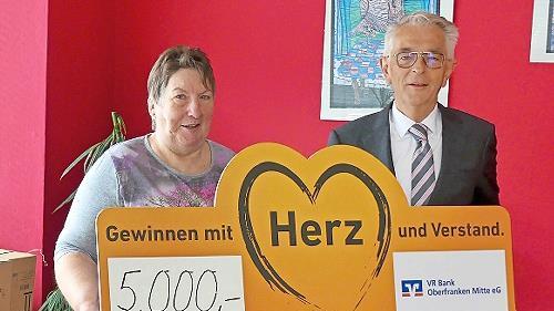 Tafel-Chefin Elfriede Höhn freut sich über die Spende der VR-Bank Oberfranken Mitte, die Gerhard Zettel übergab.
