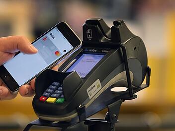 Smartphone zum Bezahlen an der Kasse eines Supermarkts