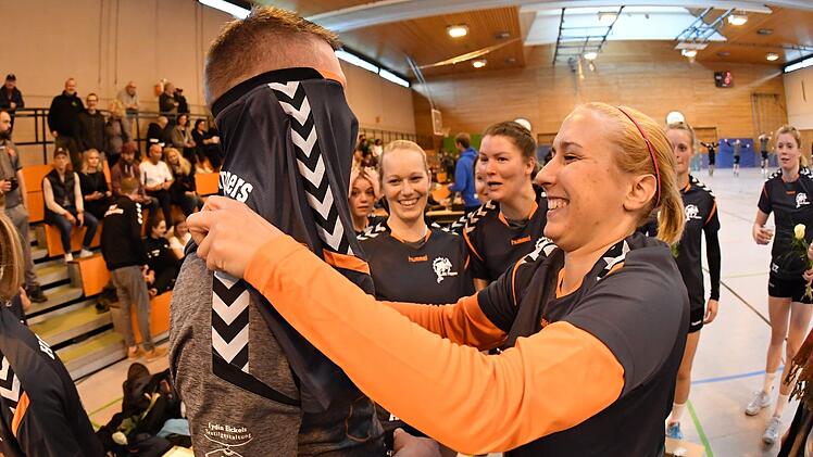 Torhüterin Katharina Heid hilft ihrem Trainer Thomas Ihrke beim Anziehen des Aufstiegs-T-Shirts.