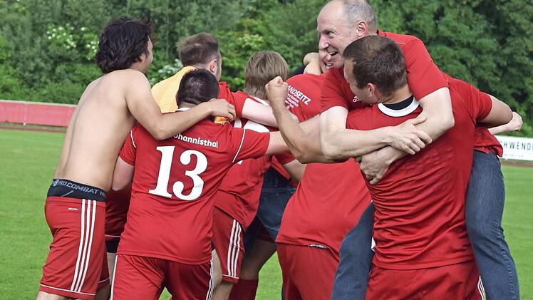 Auf diesen Jubel mussten die Spieler des VfR Johannisthal eine gefühlte Ewigkeit warten: Nachdem das Ergebnis aus Theisenort bekannt wurde, liegen sich alle in den Armen.  Foto: Dieter Radziej