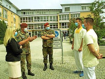 Vertreter der Bundewehr und Ministerin Melanie Huml unterhalten sich mit den Bundeswehrhelfern Philipp Kraft und Dennis Bibbo. Foto: Beck