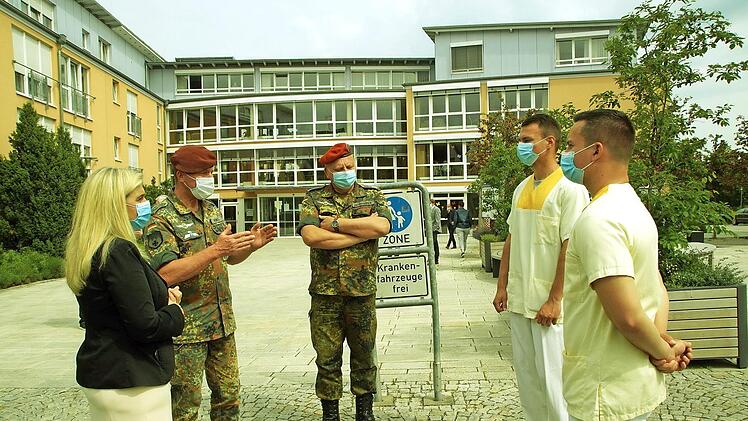 Vertreter der Bundewehr und Ministerin Melanie Huml unterhalten sich mit den Bundeswehrhelfern Philipp Kraft und Dennis Bibbo. Foto: Beck