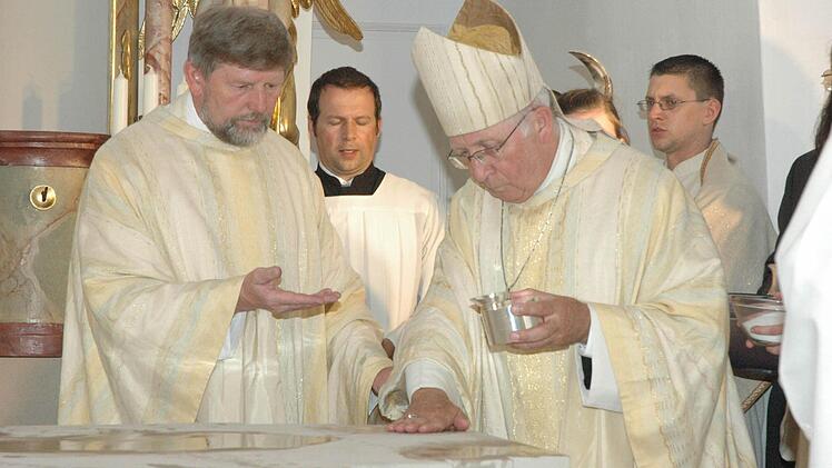 Bischof Ulrich Boom salbt unter Assistenz von Pfarrer Richard Brütting den neuen Altar. Foto: Schmidt