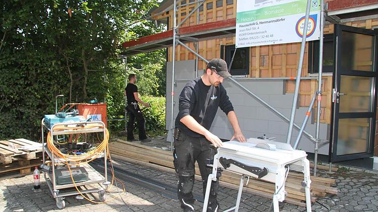 Mark Trapper und Alexander Schuberth verkleiden das Schützenhaus mit Faserzementplatten.