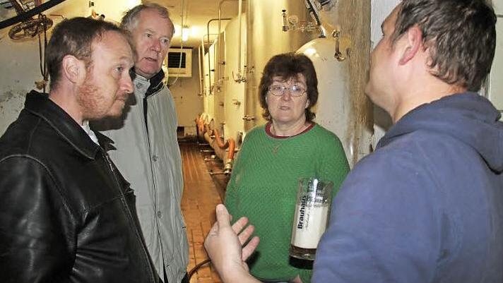 In Begleitung von Klaus Strienz (2. v. l.) ließen sich Iain und Caroline Price von Braumeister Michael Ackermann (r.) durch das Brauhaus Höchstadt führen. Foto: Johanna Blum