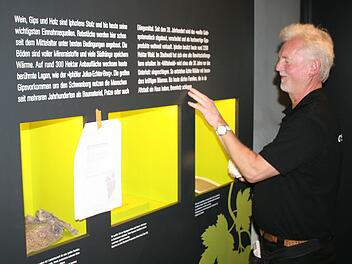 Fingerspitzengefühl ist gefragt: Karl-Heinz Kirsch vergewissert sich, dass die Beschriftung der Stele "Wein, Gips und Holz" richtig sitzt. Foto: Röllinger