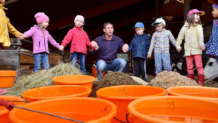 Norbert Götz hat mit den Kindern einen Kreis um die Futterration gebildet, die eine Kuh am Tag verspeist, um schließlich rund 20 Liter Milch zu geben.  Foto: Kathrin Kupka-Hahn