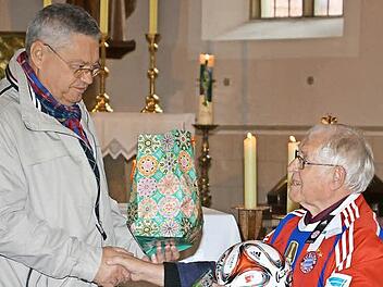 Der Vorsitzende des Pfarrgemeinderates Poppenlauer, Erhard Ledermann, überreicht Günter Brunner (rechts) Geschenke.Foto: Björn Hein